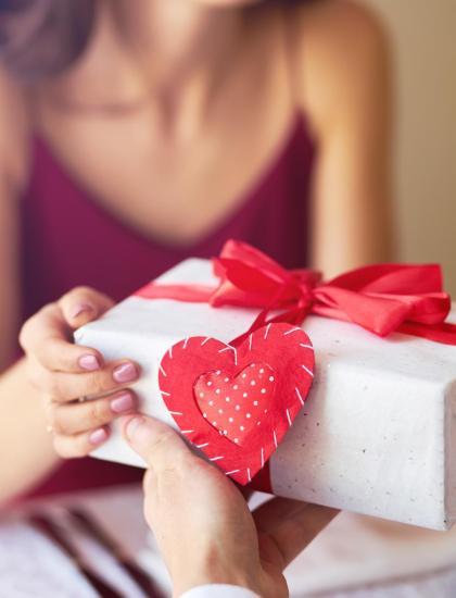Scambio di regali con cuore rosso, simbolo d'amore.