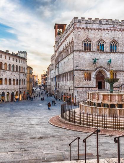 Piazza storica con fontana e palazzo medievale a Perugia.