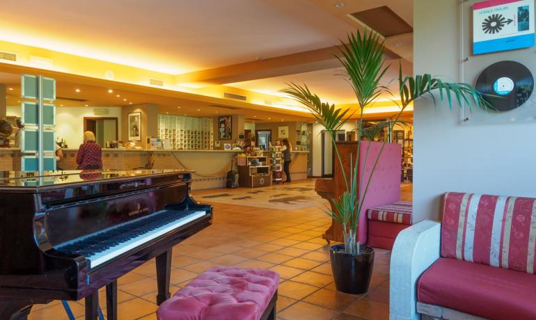 Lussuoso atrio con pianoforte e comodi divani.