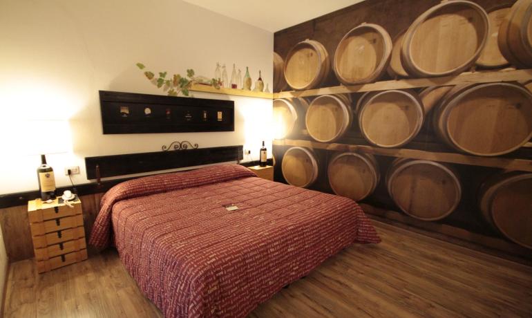 Camera accogliente con decorazioni a tema vino e botti di legno.
