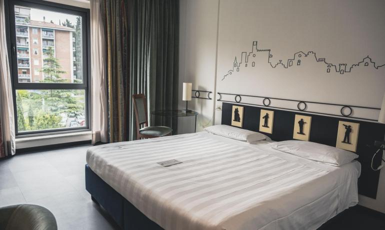 Camera d'albergo moderna con letto matrimoniale e decorazioni artistiche.