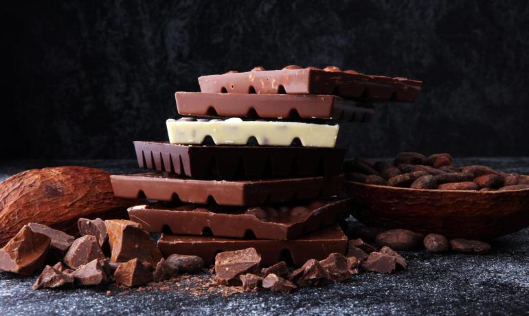 Barrette di cioccolato impilate con fave di cacao.