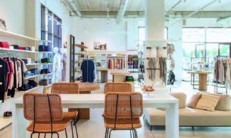 Negozio di abbigliamento moderno con arredamento elegante e accogliente.