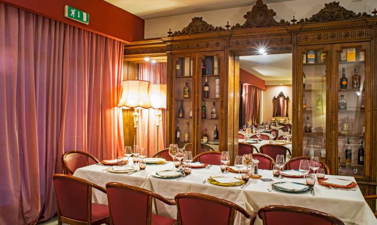 Elegante sala da pranzo con arredi classici e illuminazione calda.