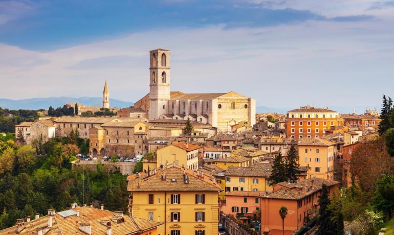 Panoramic view of Perugia with historic buildings and hilly landscape.