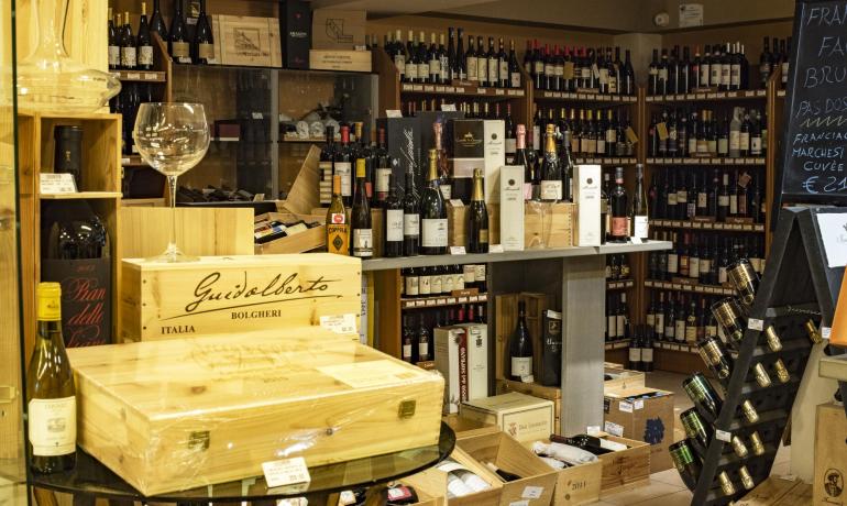 Enoteca accogliente, bottiglie pregiate e atmosfera calda.