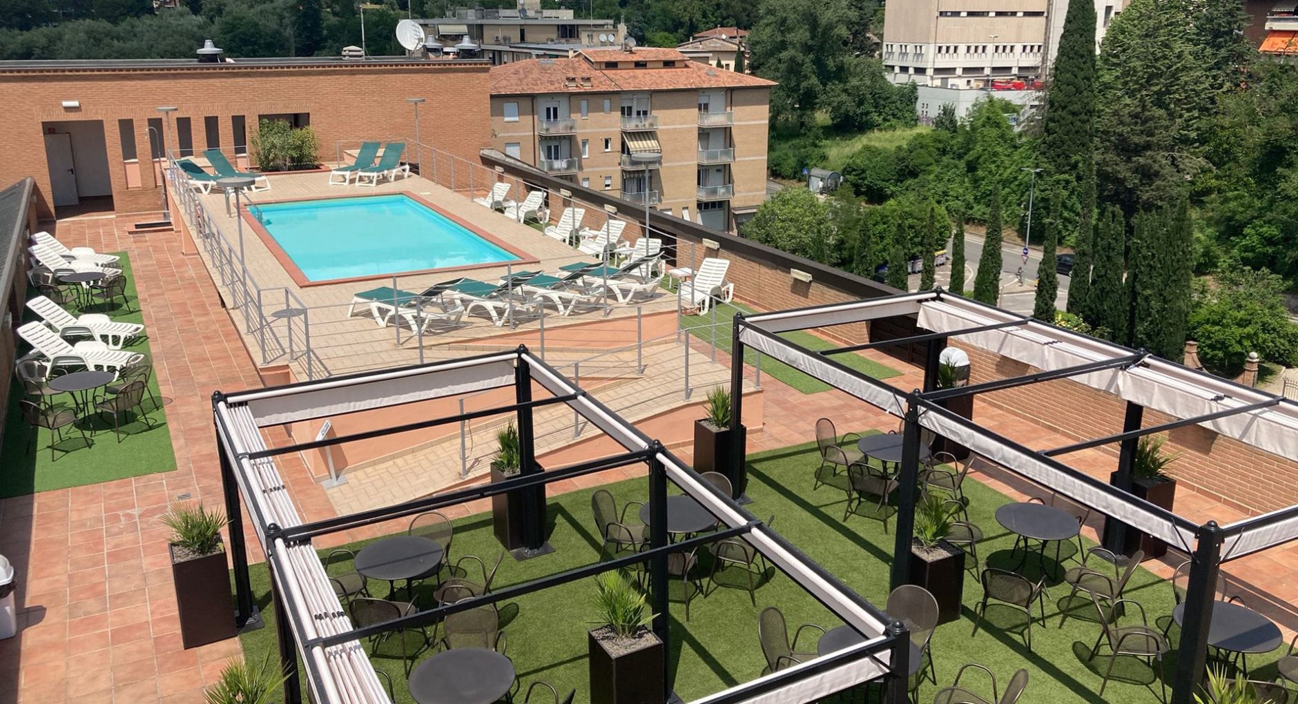 Sala accogliente con piante, divani a righe e pianoforte a coda.