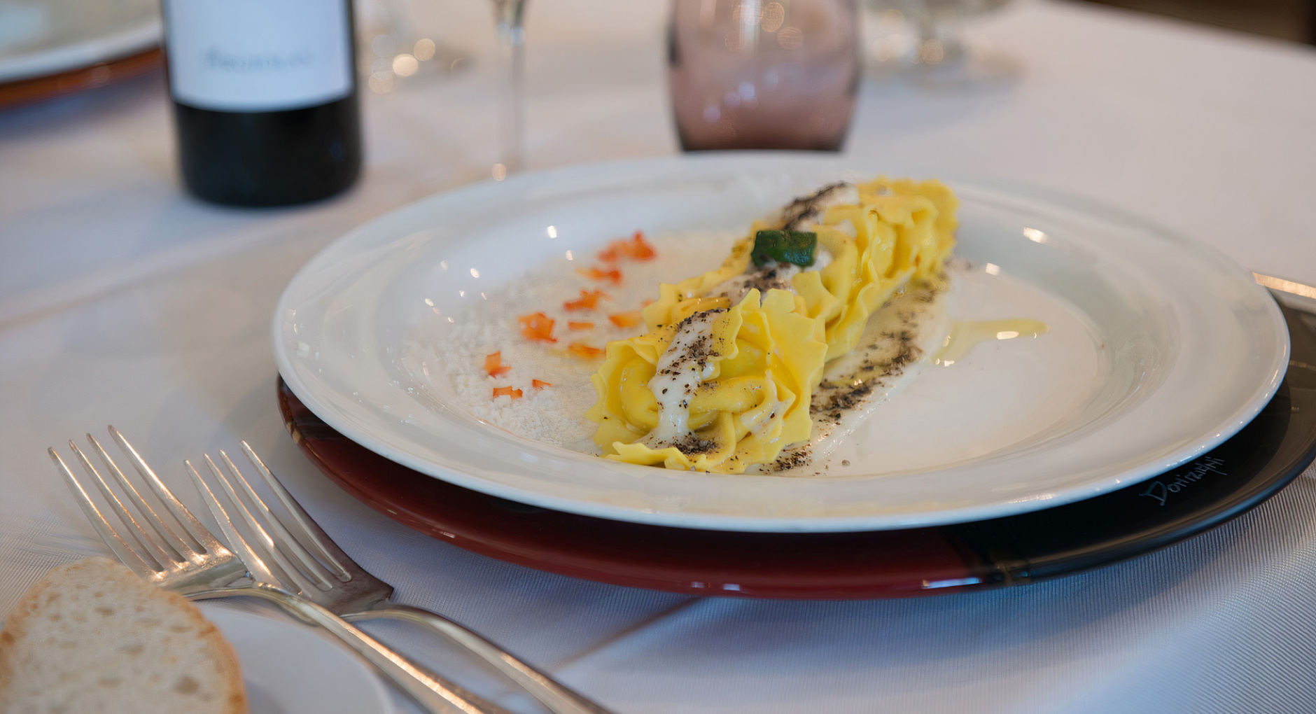 Piatto elegante di pasta con vino rosso, raffinato e invitante.