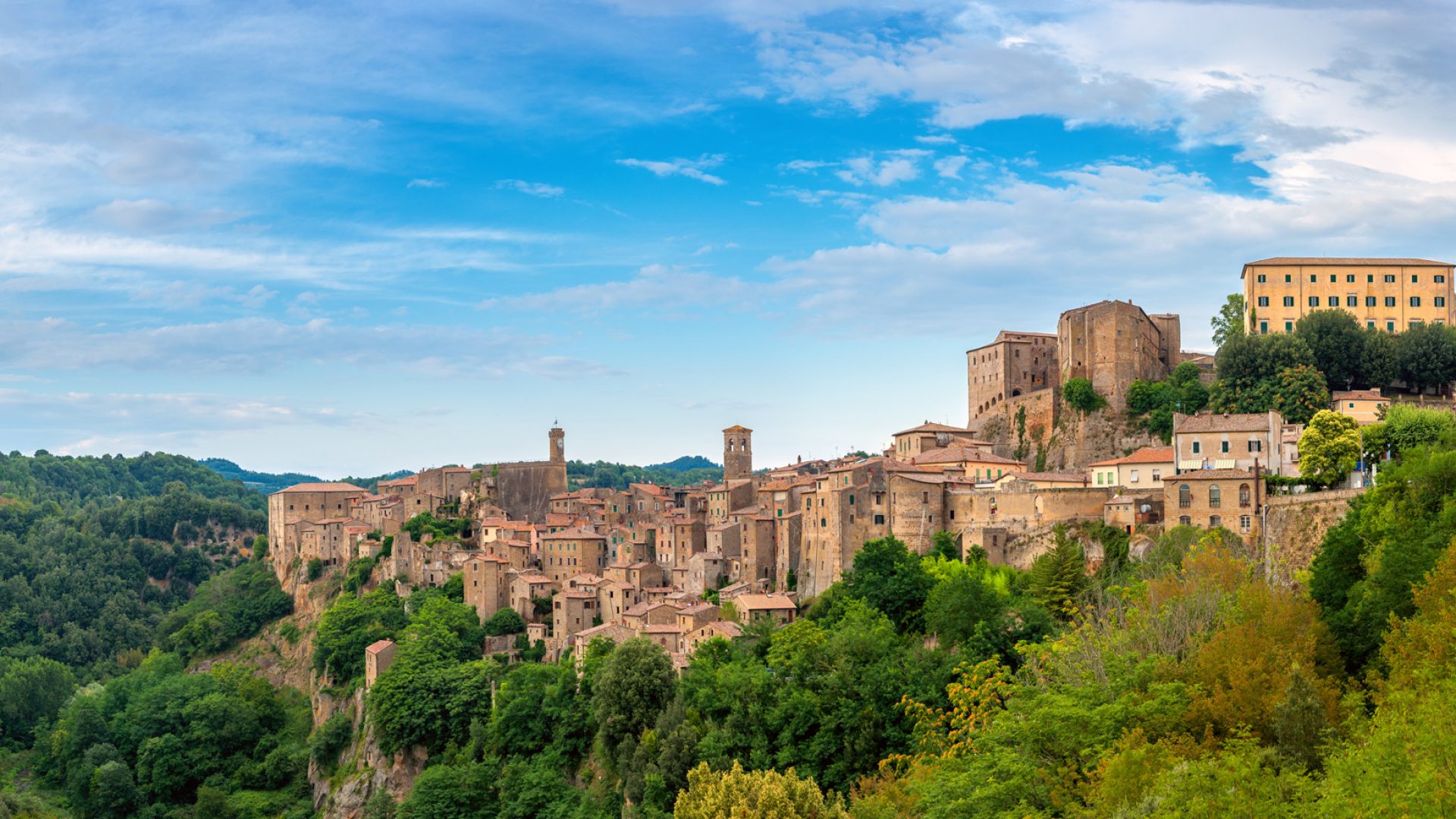 Panorama di un borgo medievale su una collina, immerso nel verde.