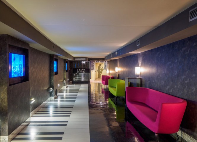 Corridoio moderno con divani colorati e decorazioni a tema jazz.