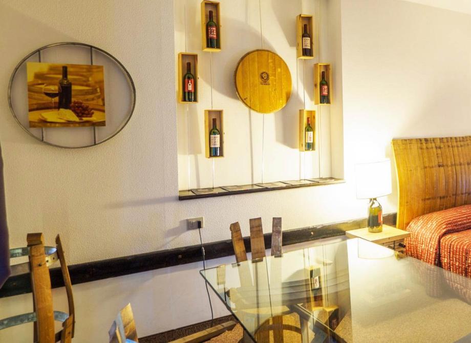 Camera accogliente con decorazioni a tema vino, calda e invitante.