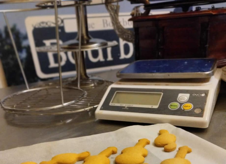 Biscotti musicali su carta forno, bilancia e atmosfera accogliente.