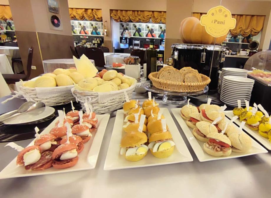 Buffet ricco di panini colorati e pane fresco, atmosfera accogliente e invitante.