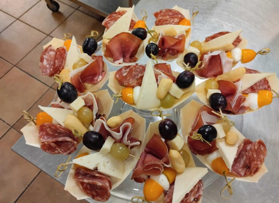 Deliziosi spiedini colorati con salumi, formaggi e frutta, perfetti per un aperitivo.