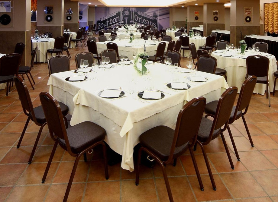Sala elegante con tavoli apparecchiati, atmosfera accogliente e calda.