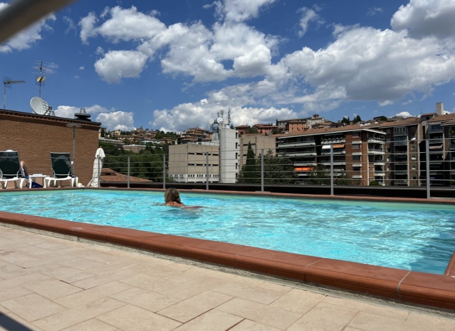 Piscine sur le toit, ciel bleu, détente urbaine.