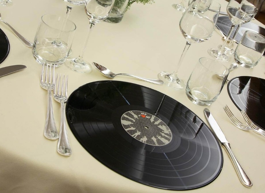 Tavola apparecchiata con sottopiatti a forma di disco in vinile.